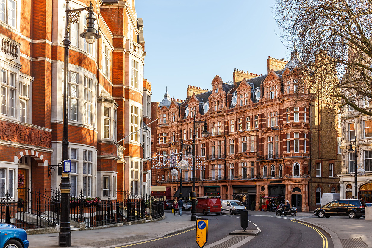 Image of red brick residential and commercial buildings in a sunny street in London